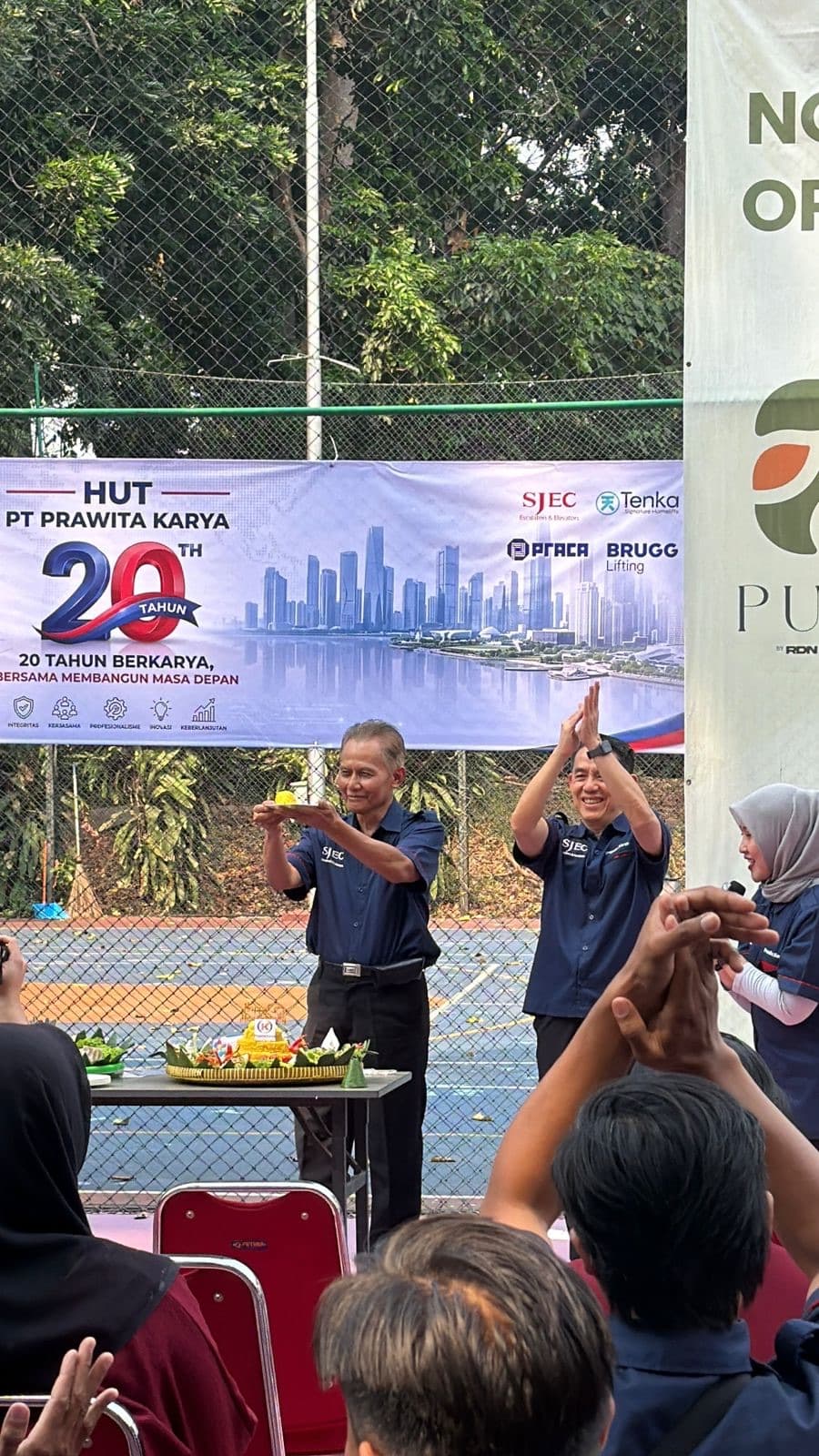 The ceremonial tumpeng being presented at the anniversary, applauded by staff