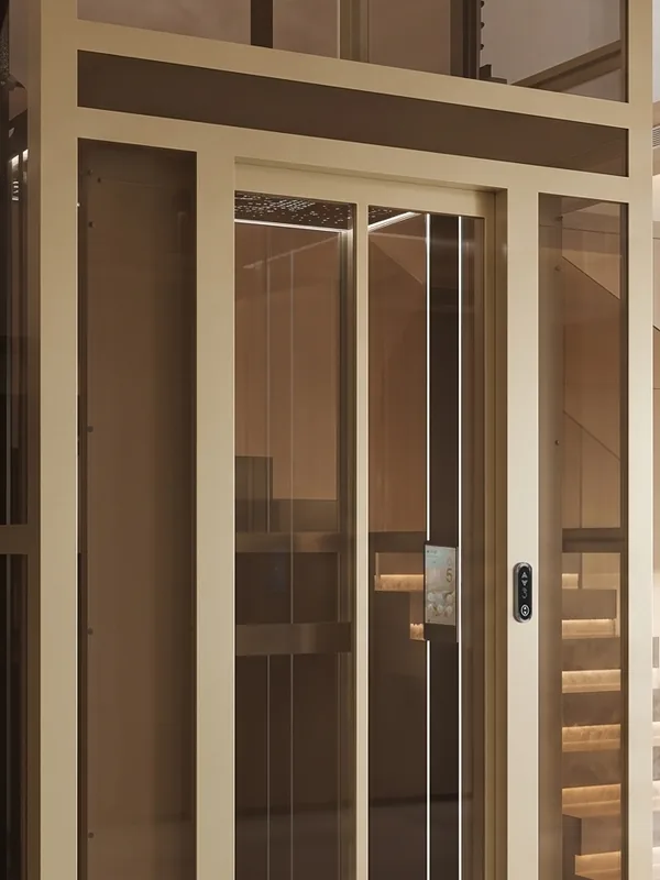 Lift rumah Kaze, sepenuhnya berkaca dengan rangka warna champagne yang dipasang pada bingkai kayu
