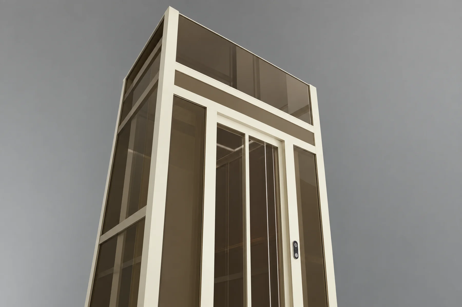 Looking up the Tenkai Kaze glazed shaft, the cream aluminium posts and glazing bars converging towards the headbox above the car door