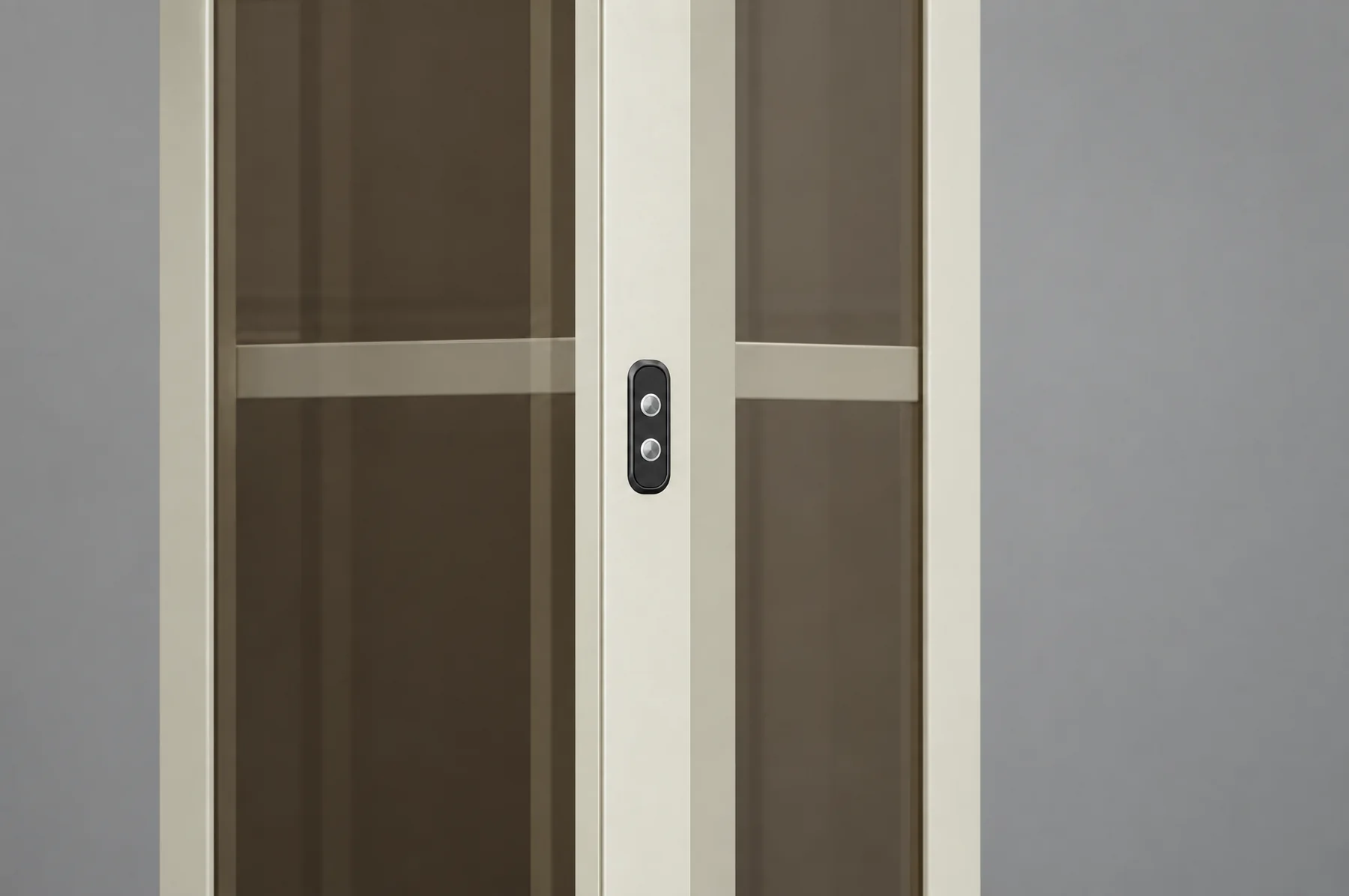 Close-up of the Tenkai Kaze landing panel, a small dark plate with two round call buttons recessed into the cream aluminium frame post between bronze glass panels