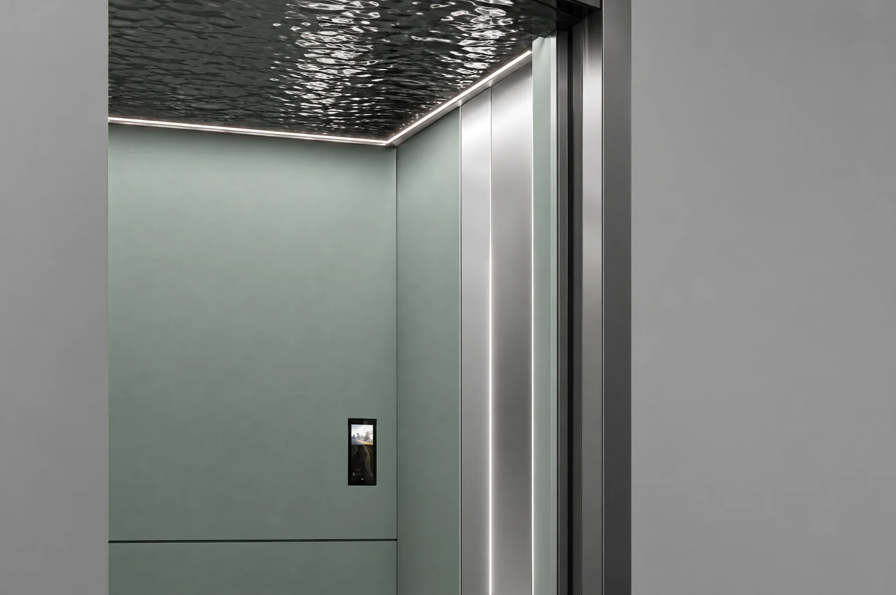 Studio close-up of the Tenkai Mizu car: a black water-ripple ceiling over a light strip, pale green wall panels, the mirror stainless entrance column and the car panel display