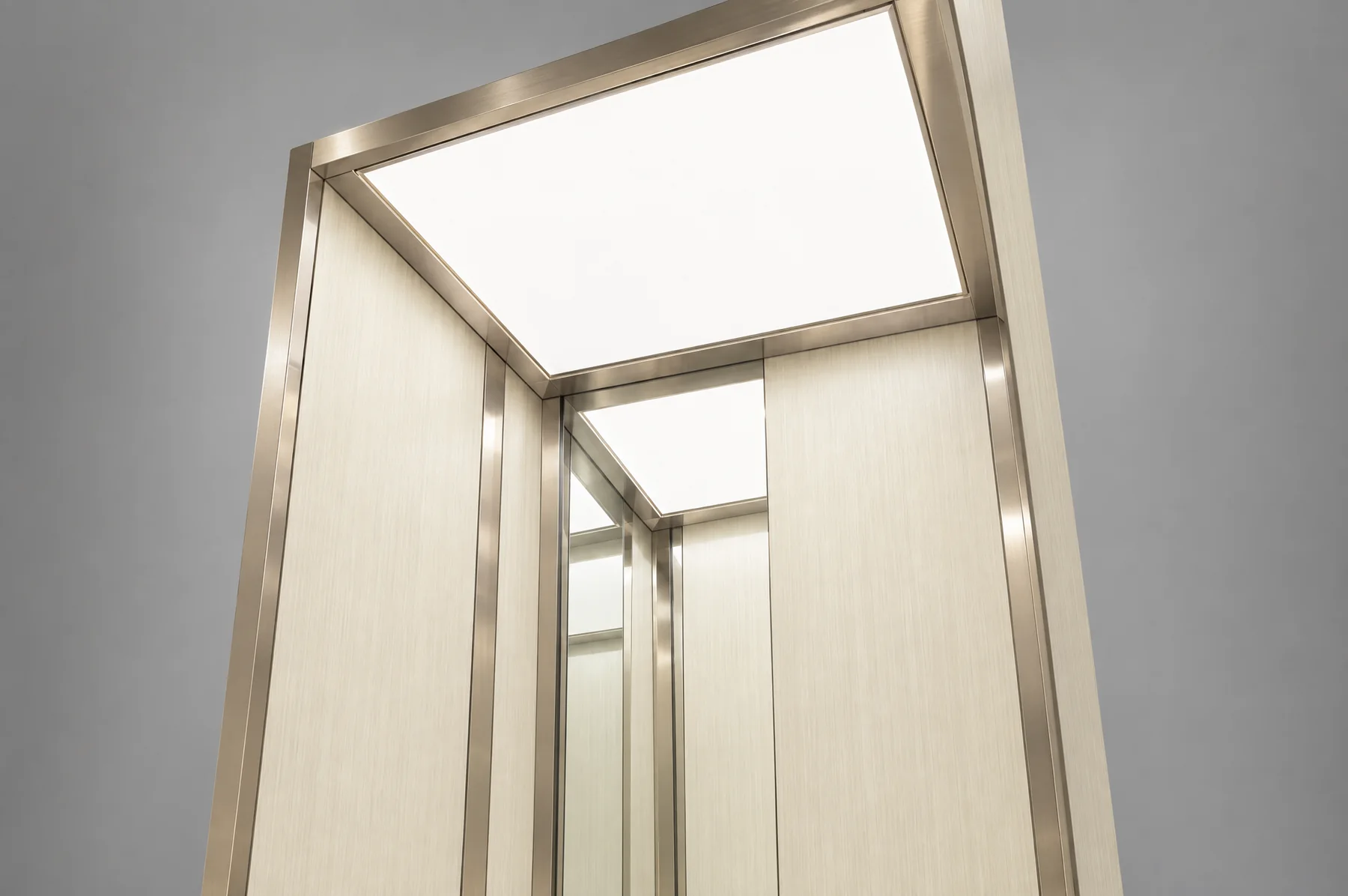 Menengadah di dalam kabin Tenkai V300 ke panel plafon rata yang menyala, dengan dinding bermotif serat gading dan trim stainless champagne menyatu di bawahnya