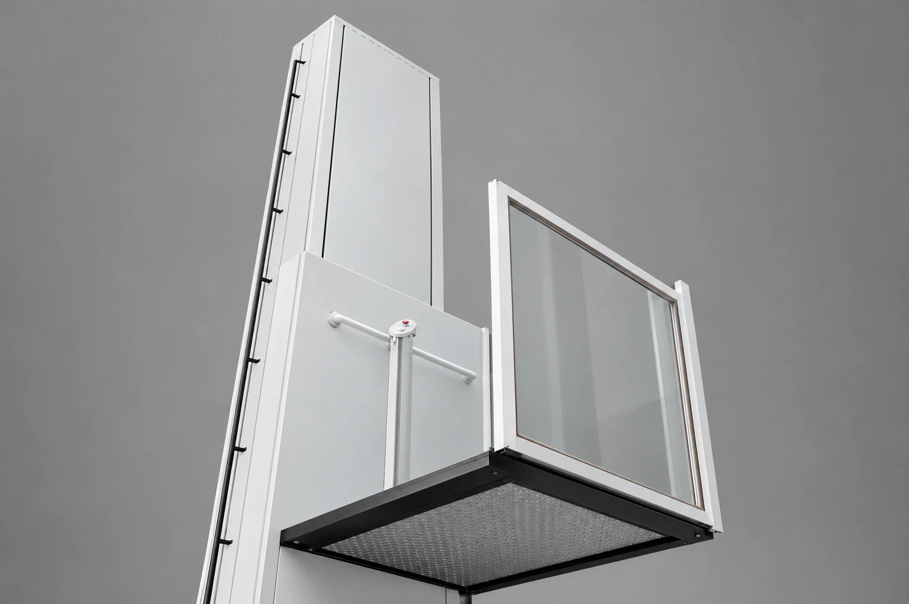 Looking up the white powder-coated mast of a wheelchair platform lift, the glass guard frame running up beside it